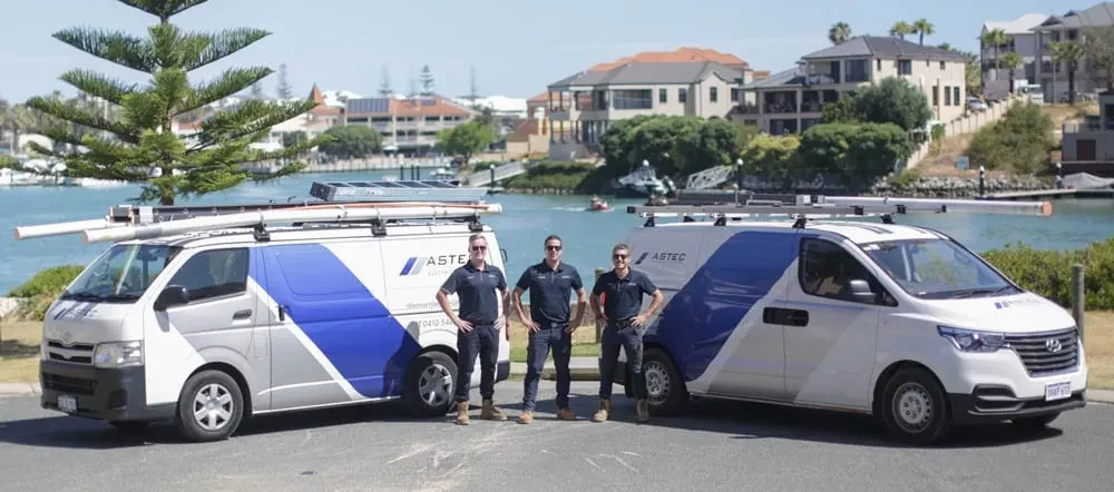 The ASTEC Electricians team with their branded vans by the coast