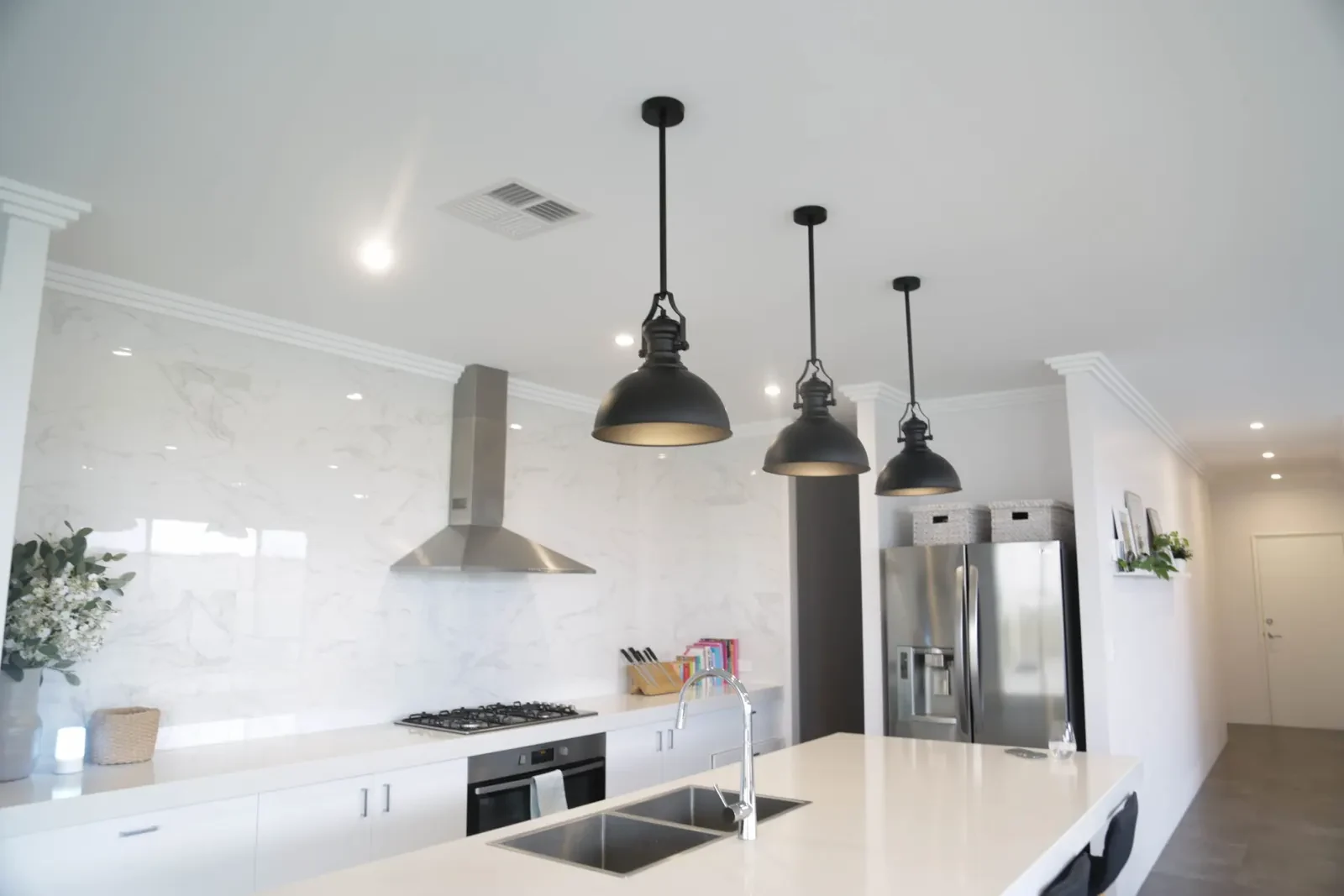 Finished kitchen with pendant lighting and downlights
