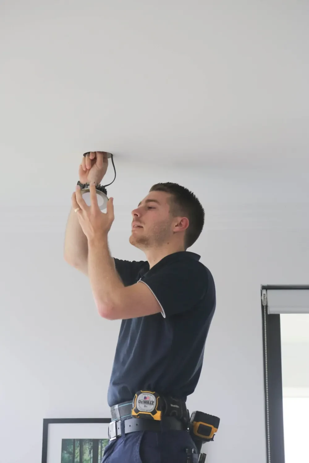 Electrician fitting a ceiling light
